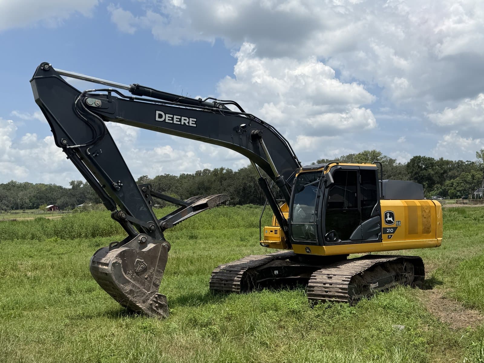 A-1 Land Management's John Deere 210 tracked excavator in a cleared field